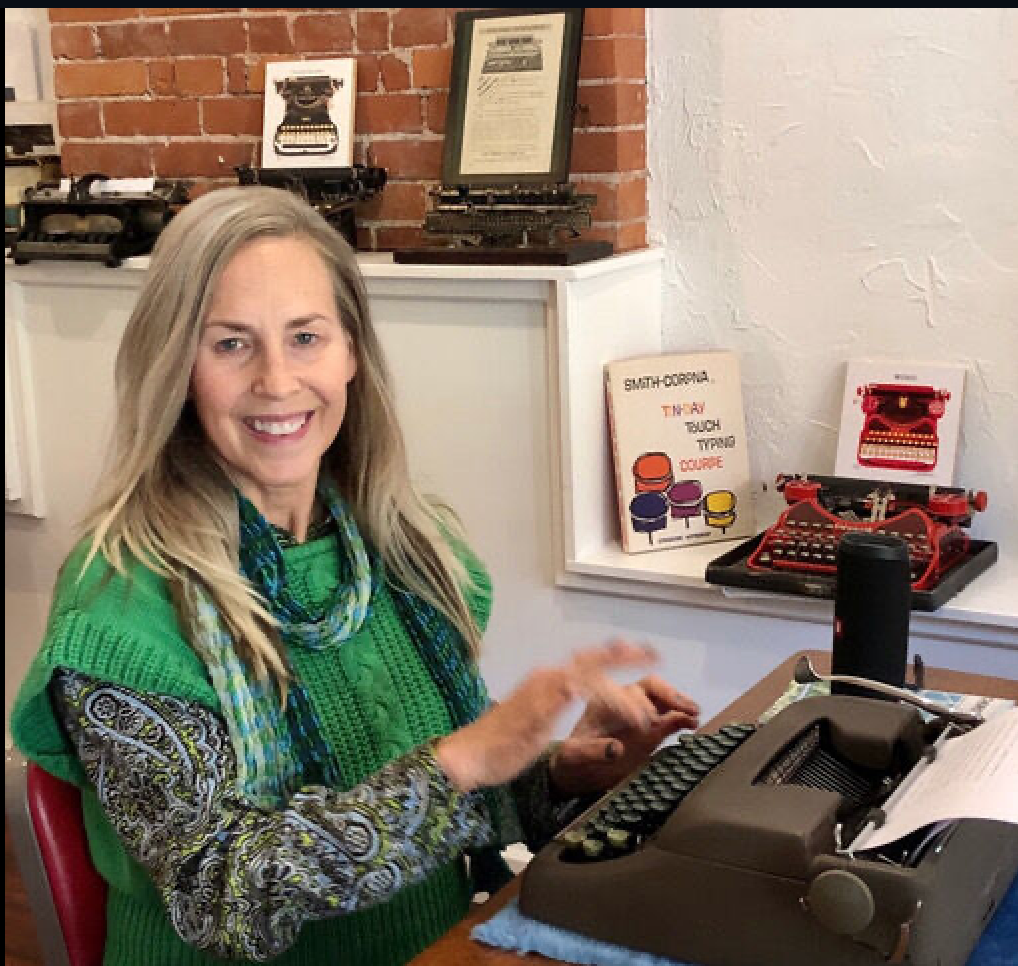 Louise in St. Louis Art Gallery typing. See the antique typewriter collection.